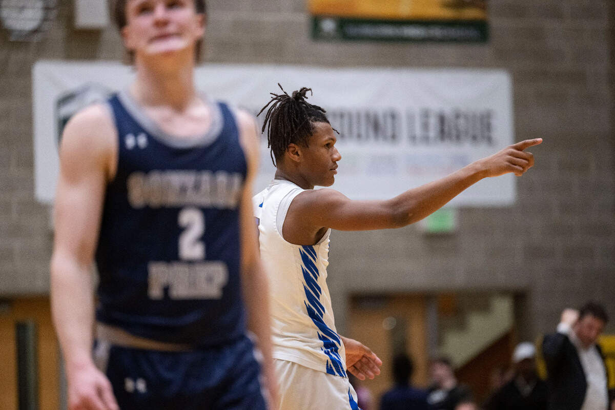 Federal Way forward Vaughn Weems (0) points to the bench after being fouled as Gonzaga Prep guard Jackson Floyd (2) looks away during the fourth quarter of a Class 4A state tournament regional game on Friday, Feb. 24, 2023, at Auburn High School in Auburn, Wash.