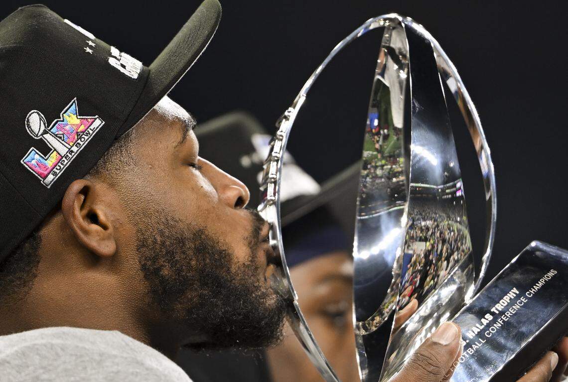 Seattle Seahawks linebacker Ernest Jones IV (13) kisses the George Halas Trophy after winning the NFC Championship game against the Los Angeles Rams at Lumen Field, on Sunday, Jan. 25, 2026, in Seattle.