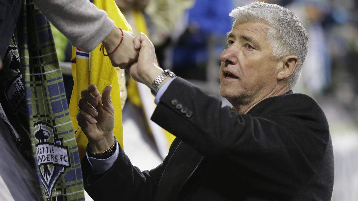 File-This Feb. 23, 2016, file photo shows Seattle Sounders head coach Sigi Schmid greeting fans after a CONCACAF Champions League soccer quarterfinal against Club America, in Seattle. The Seattle Sounders and Schmid are parting ways after eight years. The team announced Tuesday, July 26, 2016, that Schmid’s run as the only coach in the franchise’s MLS era is coming to an end. Longtime Sounders assistant Brian Schmetzer is immediately taking over as interim head coach. (AP Photo/Ted S. Warren, File)