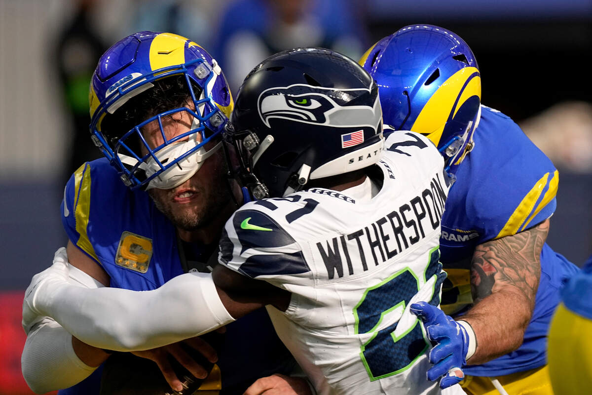 Seattle Seahawks cornerback Devon Witherspoon (21) sacks Los Angeles Rams quarterback Matthew Stafford (9) during the first half of an NFL football game Sunday, Nov. 19, 2023, in Inglewood, Calif. (AP Photo/Mark J. Terrill)