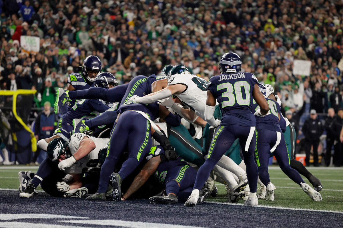 Members of the Philadelphia Eagles help quarterback Jalen Hurts, not visible, push over the goal line on a keeper to score a touchdown against the Seattle Seahawks during the second half of an NFL football game, Monday, Dec. 18, 2023, in Seattle. (AP Photo/John Froschauer)