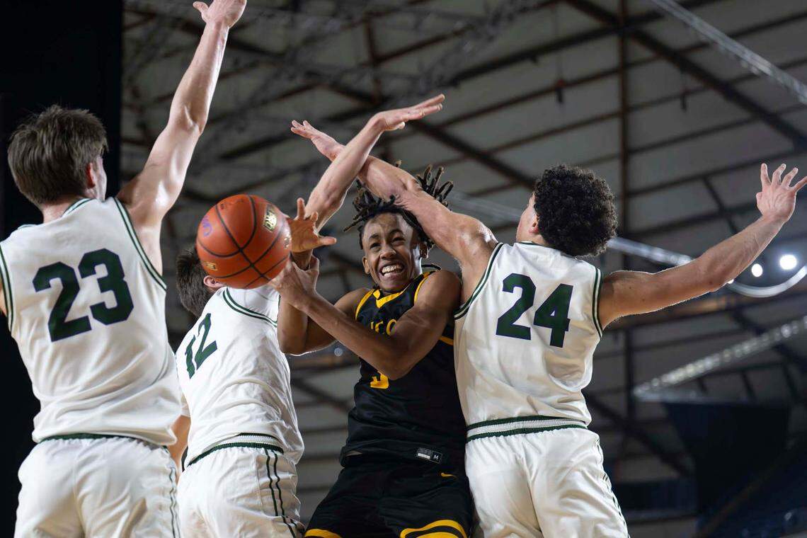 Lincoln’s Davion Shareef-Dulaney (3) hangs in the air as he attempts a shot while Edmonds-Woodway forward William Alseth (12) and forward Julian Gray (24) defend during the first half of a Class 3A state basketball tournament first-round game at the Tacoma Dome on Thursday, March 6, 2025, in Tacoma, Wash.