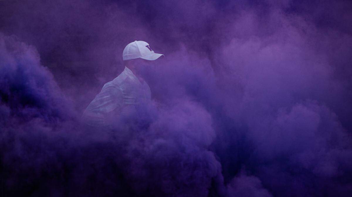 Head coach Jimmy Lake runs through the purple smoke before the game. The Washington Huskies played the Stanford Cardinal in a PAC-12 football game at Husky Stadium in Seattle, Wash., on Saturday, Dec. 5, 2020.