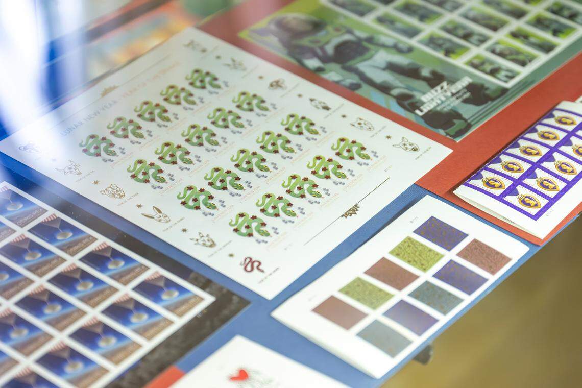 A variety of stamps sit on display at the counter of the USPS substation at Rankos Pharmacy on Wednesday, July 9, 2025, in the Stadium District of Tacoma.