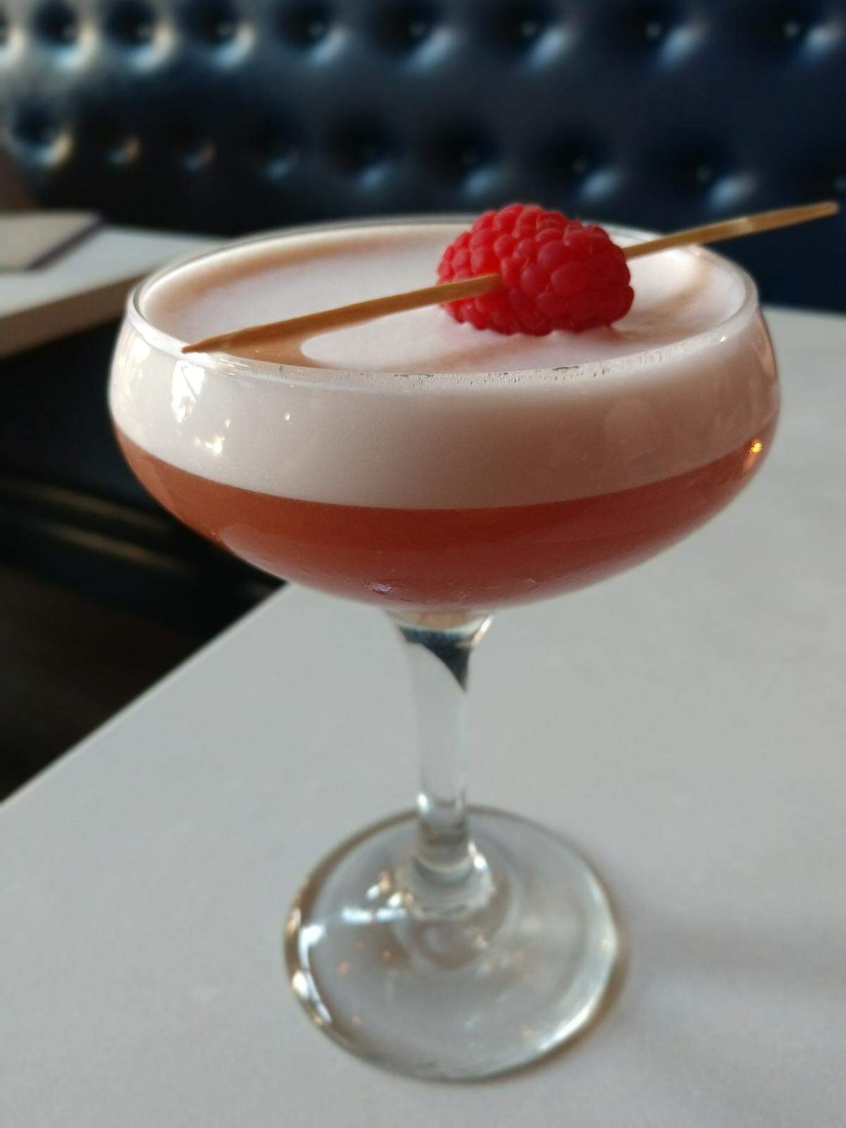 A frothy raspberry flavored vodka cocktail, called the Victoria, from Wooden City in Tacoma.