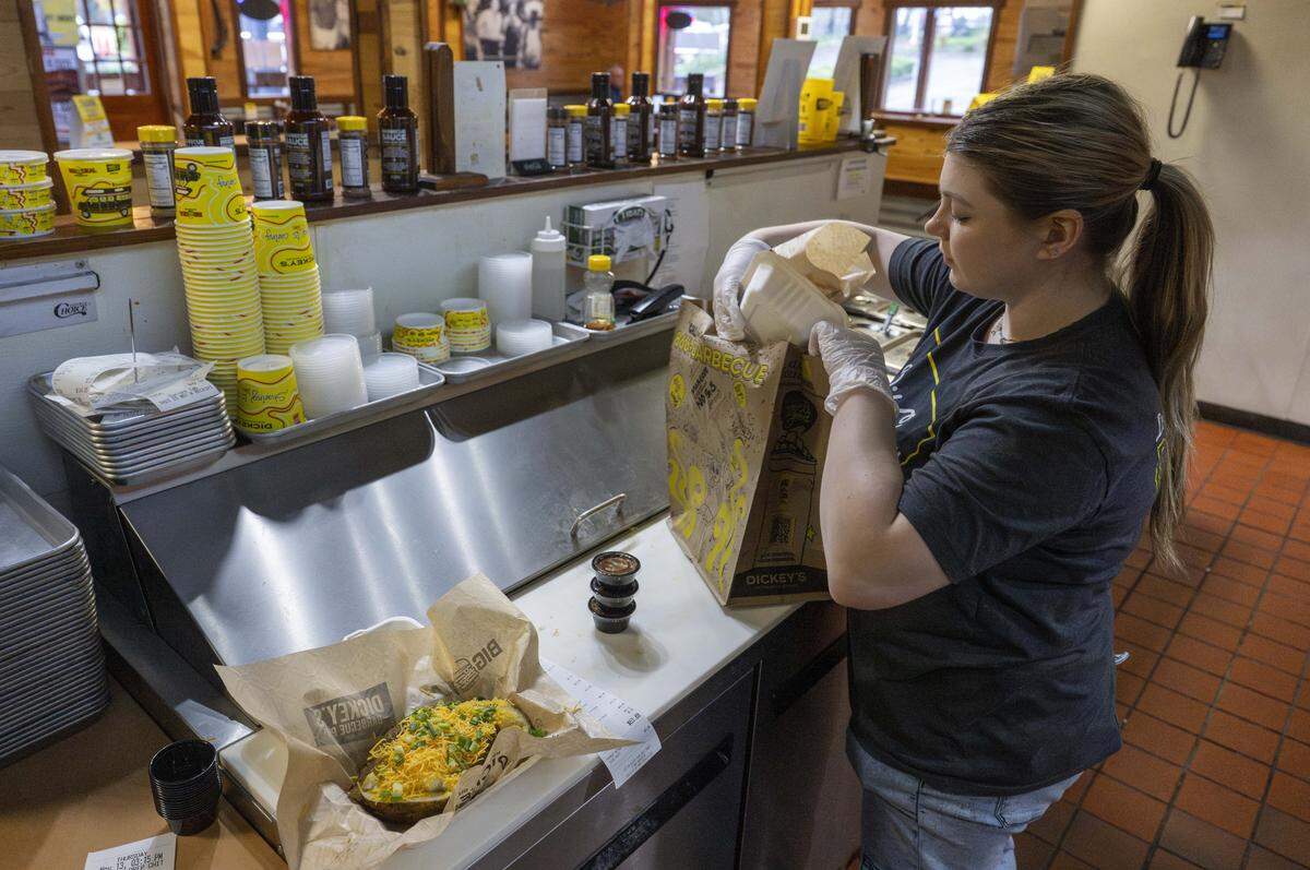 Jocelyn Macleod, a crew member at Dickey's Barbecue Pit, prepares a take out order on Thursday, Nov. 13, 2025, in Puyallup.