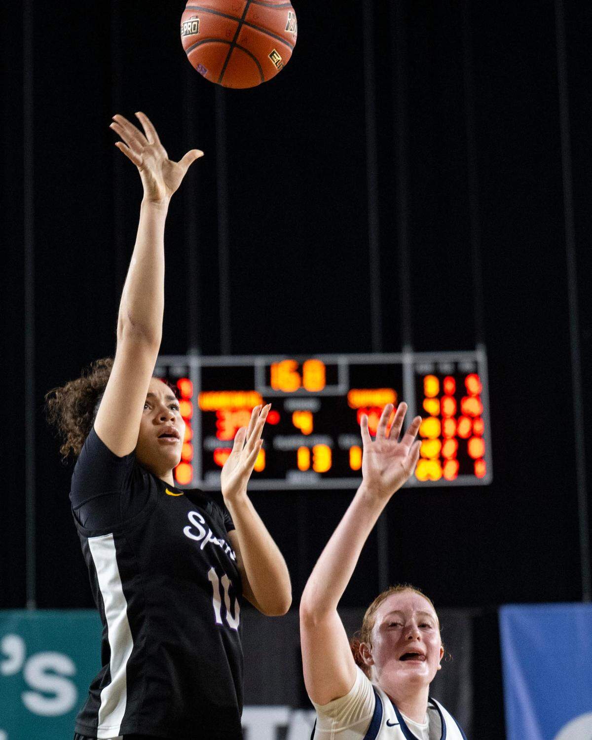 Sumner guard Olivia Collins (10) attempts a shot as Woodinville forward Hailey Quiggle (4) defends during the fourth quarter of a Class 4A state basketball tournament semifinal game at the Tacoma Dome on Friday, March 7, 2025, in Tacoma, Wash.