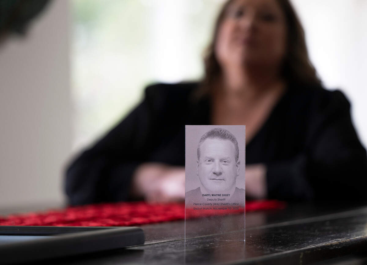 Karen Shuey holds a photo of her late husband Daryl, who suffered a heart attack while working as a Pierce County sheriff’s deputy. Photographed at the Shuey home, on Thursday, Feb. 6, 2025, in Gig Harbor.