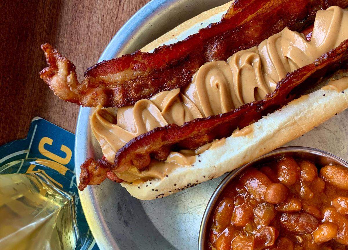The Red Hot in Tacoma is known for its stellar beer selection and wide array of fancy hot dogs, including the popular Hound Dog with peanut butter and crispy bacon (pictured here with vegetarian beer-baked beans).
