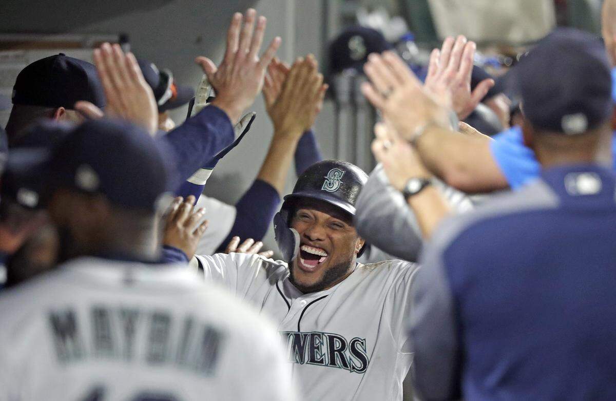 Seattle Mariners’ Robinson Cano is congratulated in the dugout after his three run home run against the Houston Astros in the eighth inning of a baseball game Monday, Aug. 20, 2018, in Seattle. (AP Photo/Elaine Thompson)