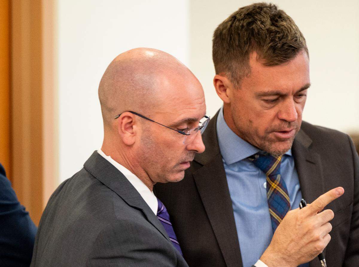 Defense attorneys Jared Ausserer (left) and Casey Arbenz talk during the trial of Tacoma police officers Christopher Burbank, Matthew Collins and Timothy Rankine in the killing of Manny Ellis.