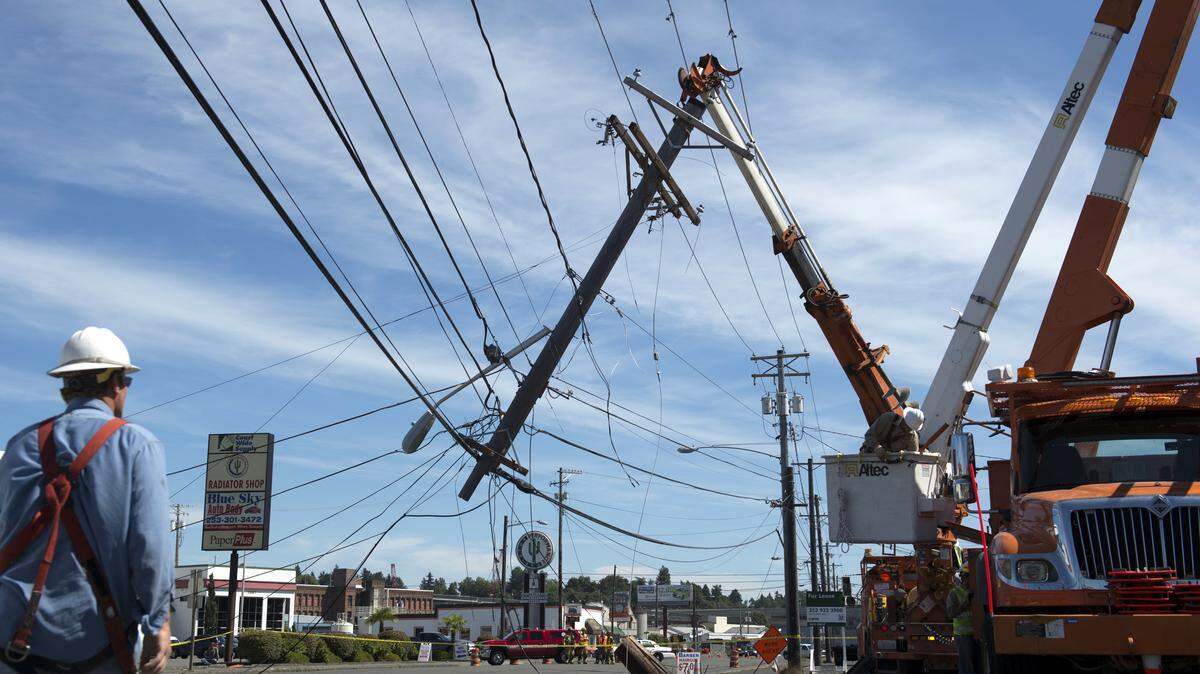 Crews work on a downed power line, which snapped after a garbage truck accidentally snagged the lines while driving on South Tacoma Way near the intersection with South Pine Street in Tacoma in August 2013. A new pilot project approved by the City Council calls for a 30-percent contribution from Tacoma Power for overhead-to-underground power line conversions for commercial and multifamily developments in Tacoma's Brewery District.