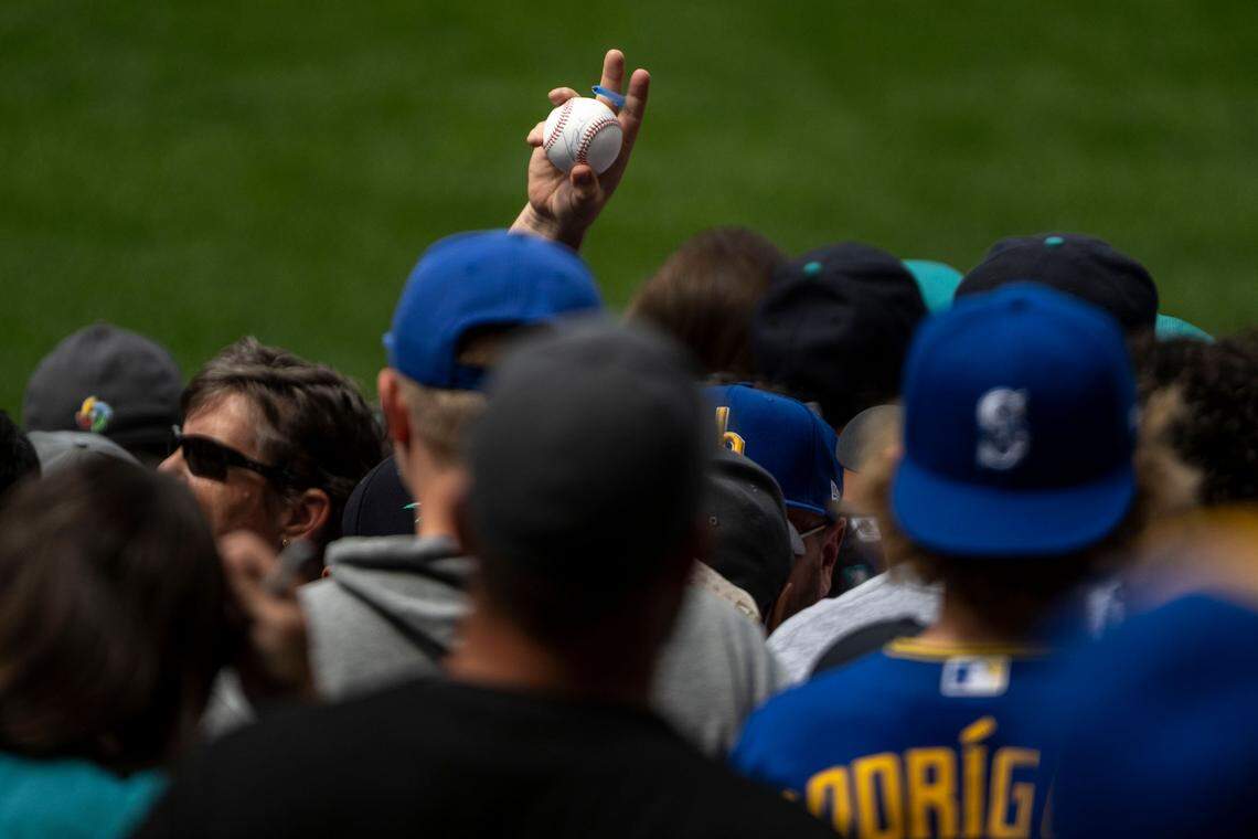 A fan holds up a signed baseball by Mariners’ All-Star pitcher Luis Castillo prior to the start of the 2023 MLB Home Run Derby on Monday, July 10, 2023, at T-Mobile Park in Seattle.
