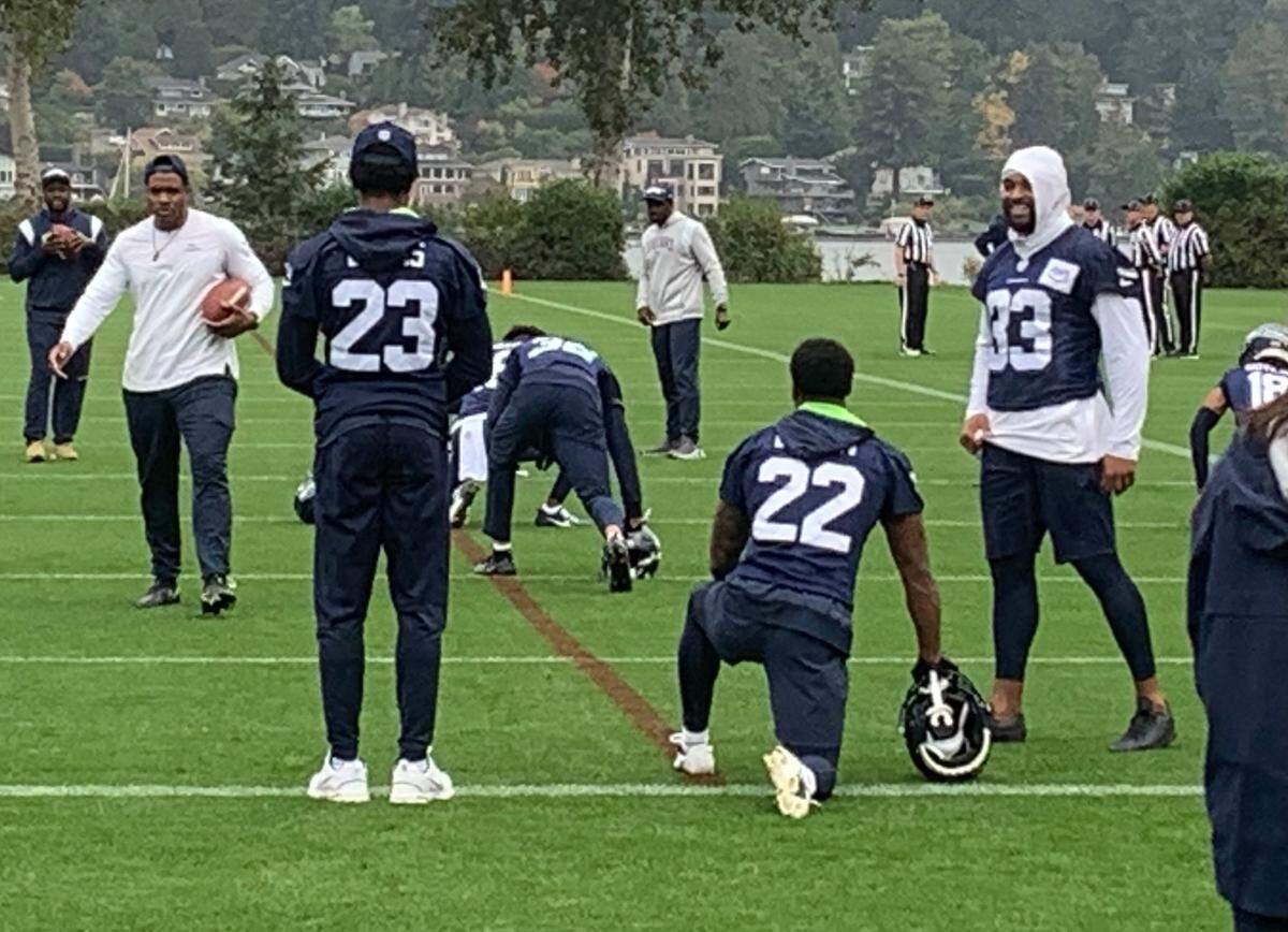 Seahawks safety Jamal Adams (right) jokes with teammates Tre Brown (22) and Artie Burns (23) at the start of practice Oct. 9, 2023, at the team facility in Renton. Adams was concussed Oct. 2 early in Seattle’s win at the New York Giants, his first game in 13 months.