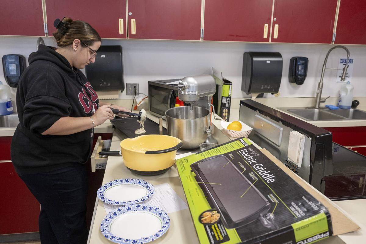 Students utilize electric griddles in a culinary classroom on Wednesday, Oct. 15, 2025, at Orting High School in Orting, Wash. Culinary courses would be moved to a new Career and Technical Education wing with dedicated spaces if the Orting School District's $137 million bond were to pass.