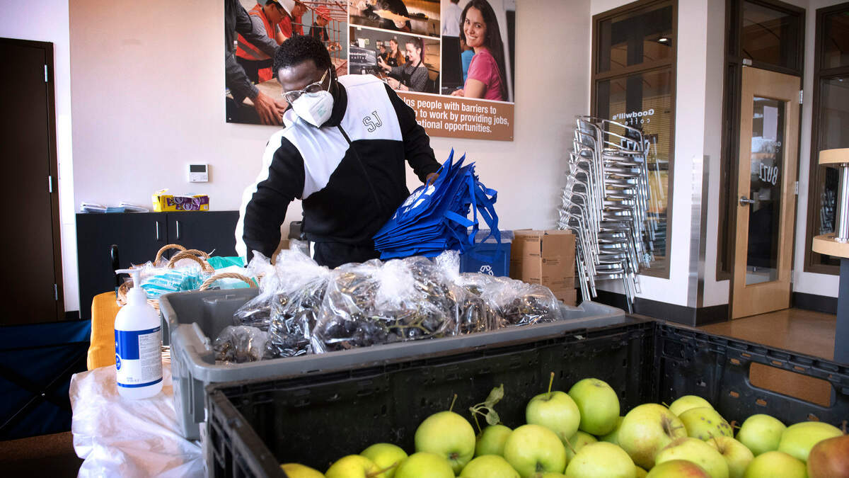 Brendan Nelson, president of the Hilltop Action Coalition, prepares fresh apples, grapes and other foods to be given away as part of the Hilltop Fed project in the former Coffee Buzz location in the Community Healthcare building on MLK Jr. Way in Tacoma, Washington, on Wednesday, Sept. 29, 2021.