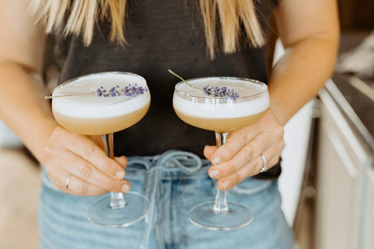 Nancy’s Whiskey Sour calls for rye (although you can use bourbon, too), fresh lemon juice, an egg white or vegan substitute like aquafaba, soda and lavender-honey syrup from the book, but playing with other flavors is always encouraged. Enjoy with friends, say Kelly, Cunningham and their grandmother.
