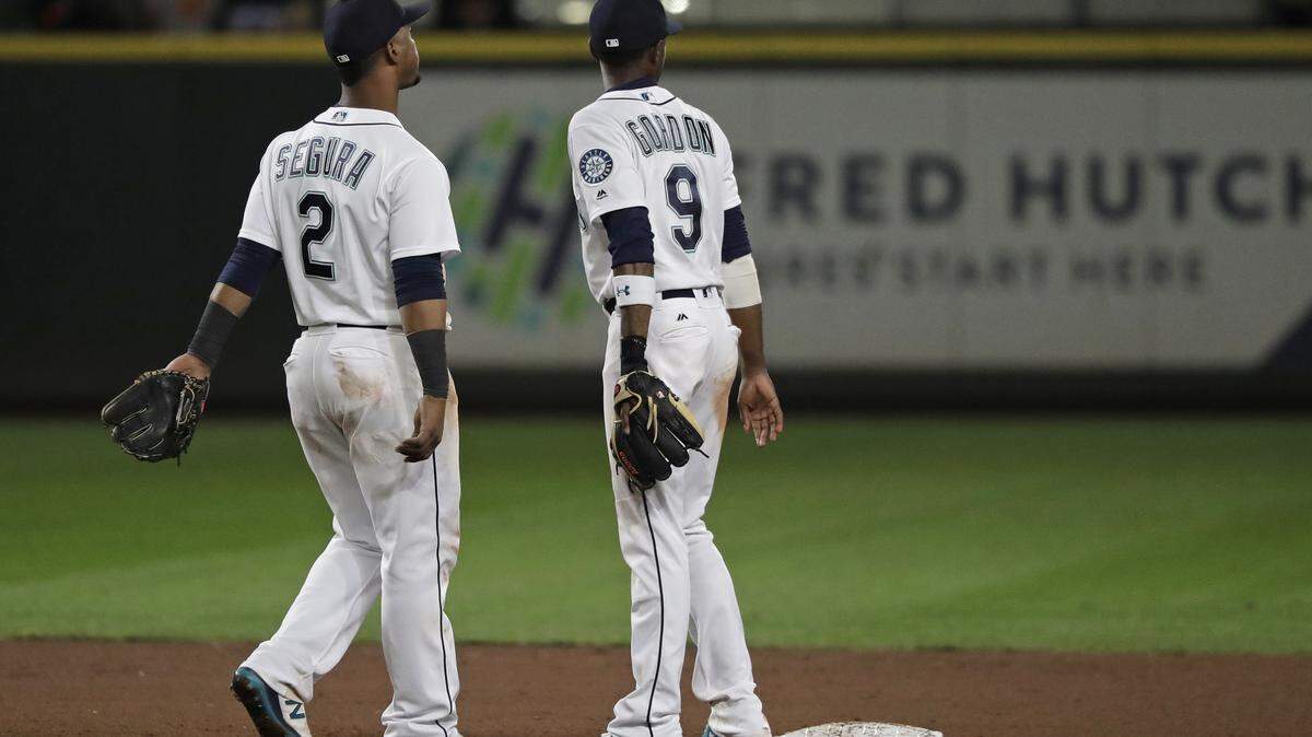 Seattle Mariners shortstop Jean Segura (2) and second baseman Dee Gordon (9) wait to greet teammates after the Mariners defeated the Baltimore Orioles 5-2 in a baseball game Wednesday, Sept. 5, 2018, in Seattle. (AP Photo/Ted S. Warren)