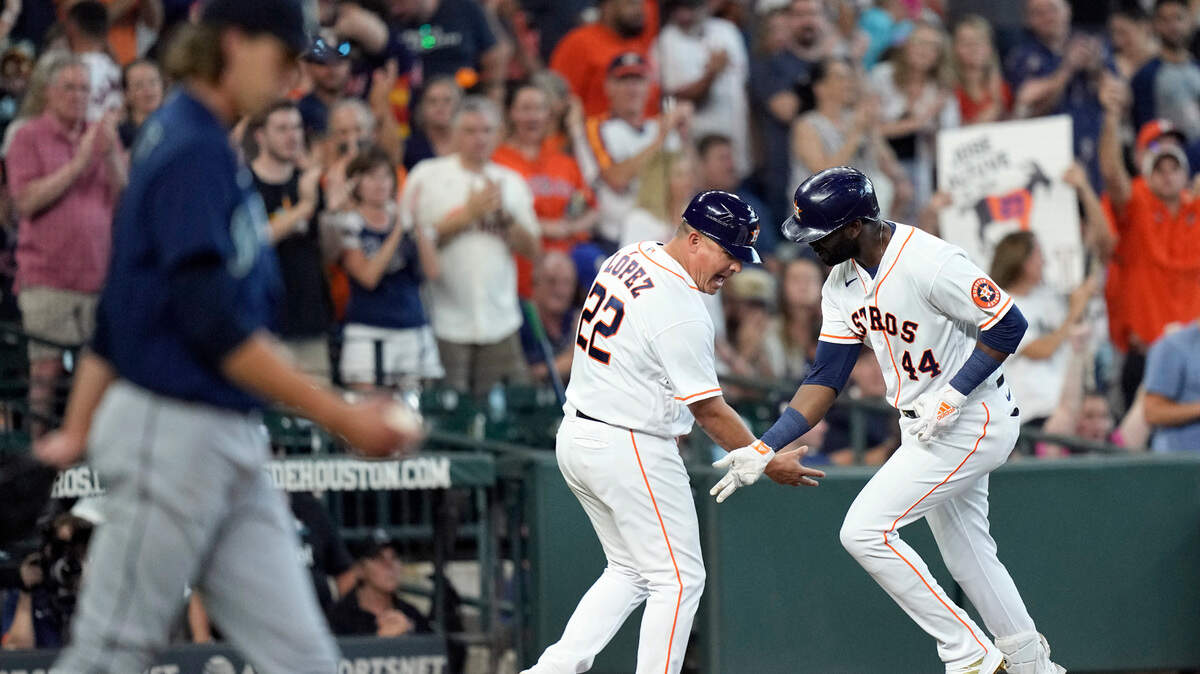 Houston Astros’ Yordan Alvarez (44) celebrates with third base coach Omar Lopez (22) after hitting a three-run home run off Seattle Mariners starting pitcher Logan Gilbert, left, during the third inning of a baseball game Saturday, Aug. 21, 2021, in Houston. (AP Photo/David J. Phillip)