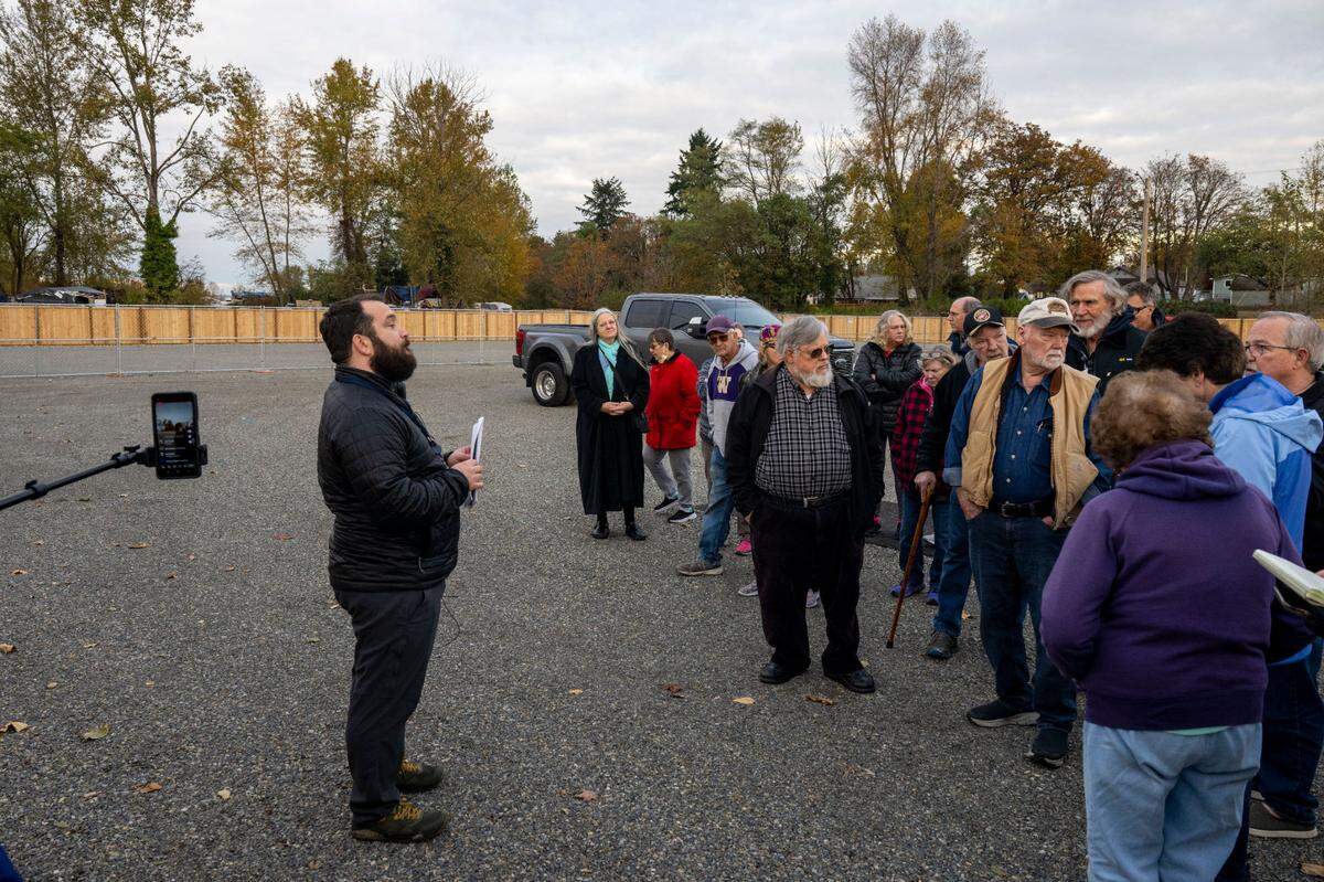 Community members pepper Caleb Carbone, homeless strategy, systems and services manager for the city of Tacoma, with questions concerning the opening of a new homeless mitigation site on the 3500 block of Pacific Avenue on Thursday, Nov. 10, 2022, in Tacoma, Wash.