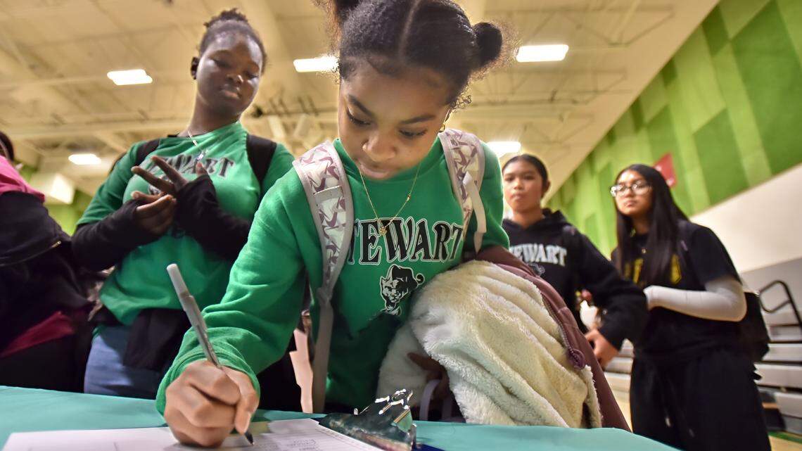 Girls in Tacoma sign up to learn more about a new flag football league at an assembly at Stewart Middle School in October 2025.