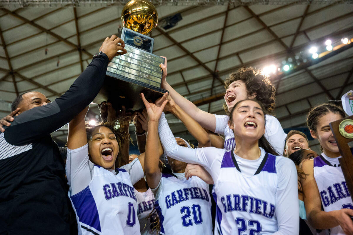 Garfield players hoist the Class 3A state championship trophy after beating Lake Washington, 39-38, on Saturday, March 5, 2022, at the Tacoma Dome, in Tacoma, Wash.