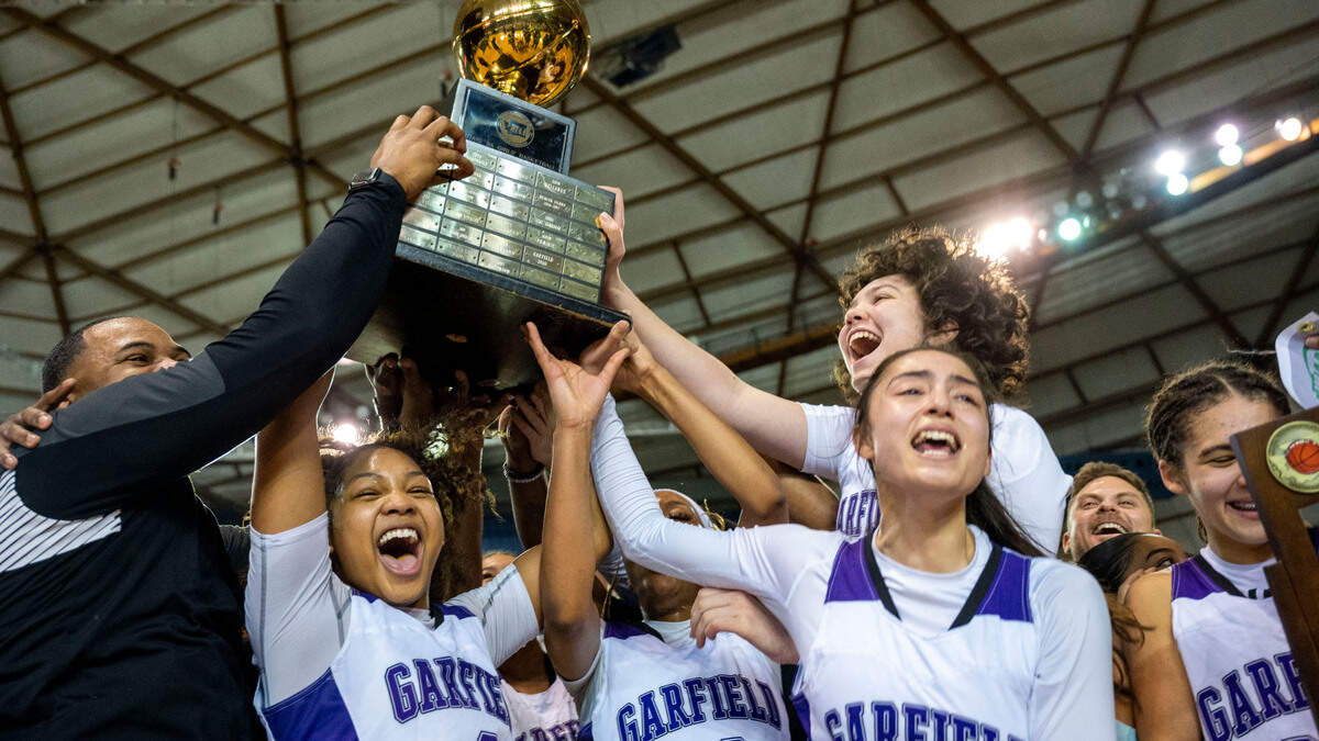 Garfield players hoist the Class 3A state championship trophy after beating Lake Washington, 39-38, on Saturday, March 5, 2022, at the Tacoma Dome, in Tacoma, Wash.
