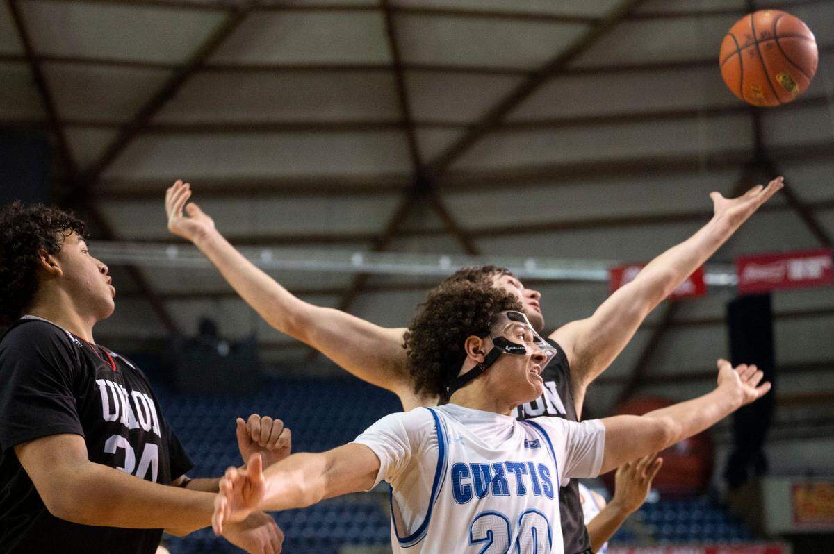Curtis forward Trent Williams (20) reaches out for a rebound along with Union forward Josiah Baldassare (35) during the fourth quarter of a Class 4A semifinal state tournament game on Friday, March 4, 2022, at the Tacoma Dome, in Tacoma, Wash.