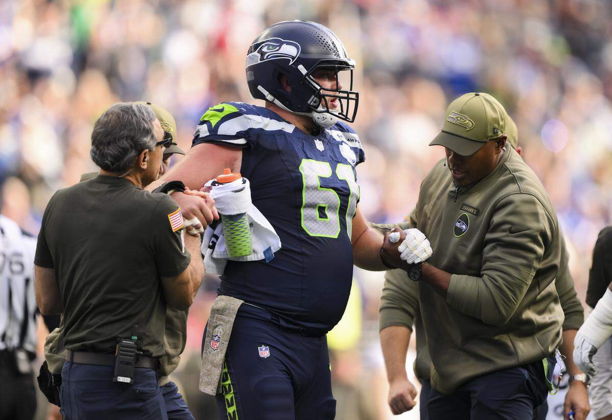 Seattle Seahawks center Jalen Sundell (61) is helped off the field during the second quarter of the game against the Arizona Cardinals at Lumen Field, on Sunday, Nov. 9, 2025, in Seattle.