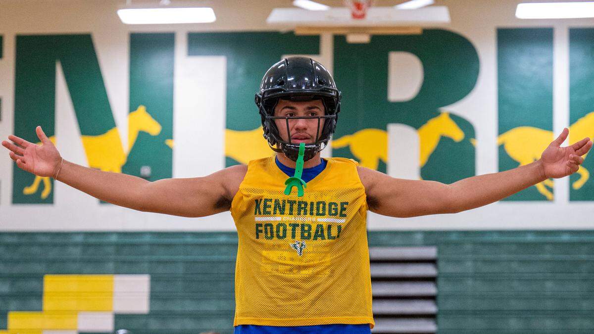 Kentridge quarterback Dorian Thomas talks over a play with his receivers during practice inside the school’s gym on Wednesday, Sept. 21, 2022, in Kent, Wash. Although Thomas quarterbacks the Chargers, we has committed to Oregon State where he will play tight end.
