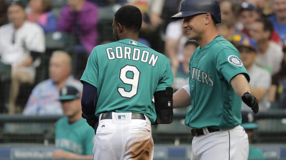 Seattle Mariners’ Kyle Seager, right, greets Dee Gordon (9) after Gordon scored on a sacrifice fly by Nelson Cruz during the first inning of the team’s baseball game against the Chicago White Sox, Friday, July 20, 2018, in Seattle. (AP Photo/Ted S. Warren)