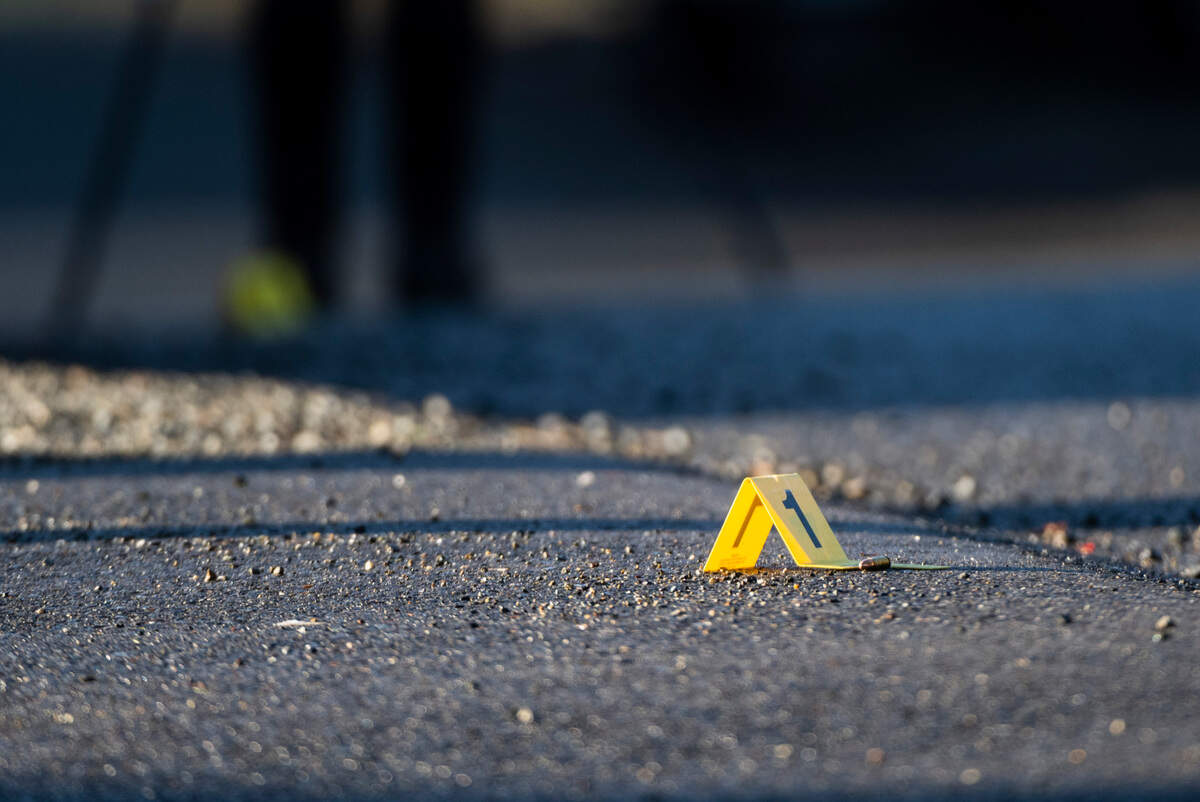 A marker is placed next to a shell casing found on the scene where a woman was found deceased and a man sustained life threatening injuries after being shot on the 3800 block of East Howe Street in Tacoma, Wash. on Sunday, March 13, 2022.