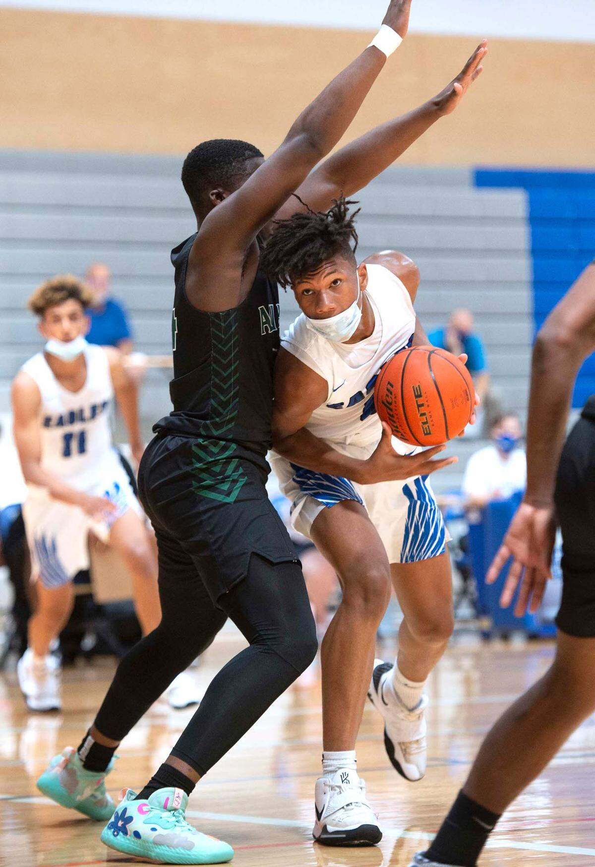 Federal Way’s Vaughn Weems tries to power past Auburn defender DaeKwon Watson during the 3A/4A NPSL boys basketball crossover championship game at Federal Way High School in Federal Way, Washington, on Saturday, June 26, 2021.
