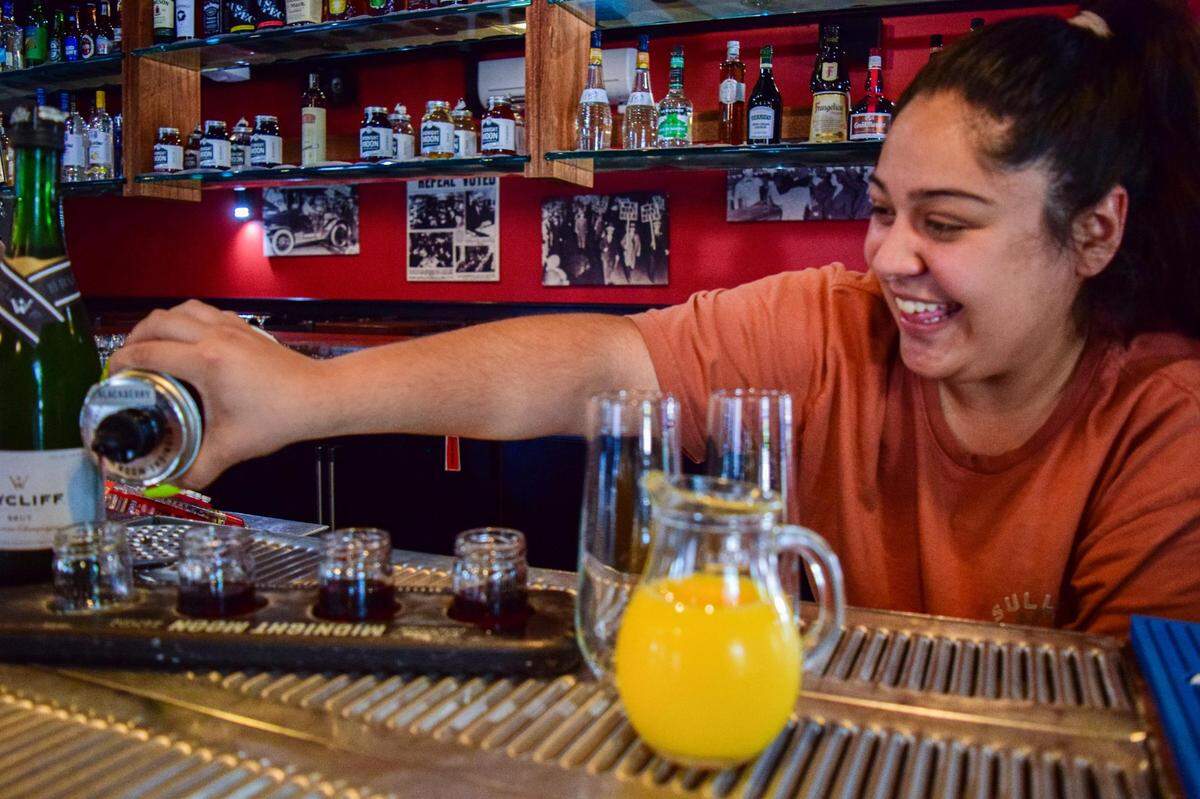 Bartender Yessly Reyes pours a moonshine mimosa flight at Dirty Oscar’s Annex, one of the restaurant’s most common brunch orders.