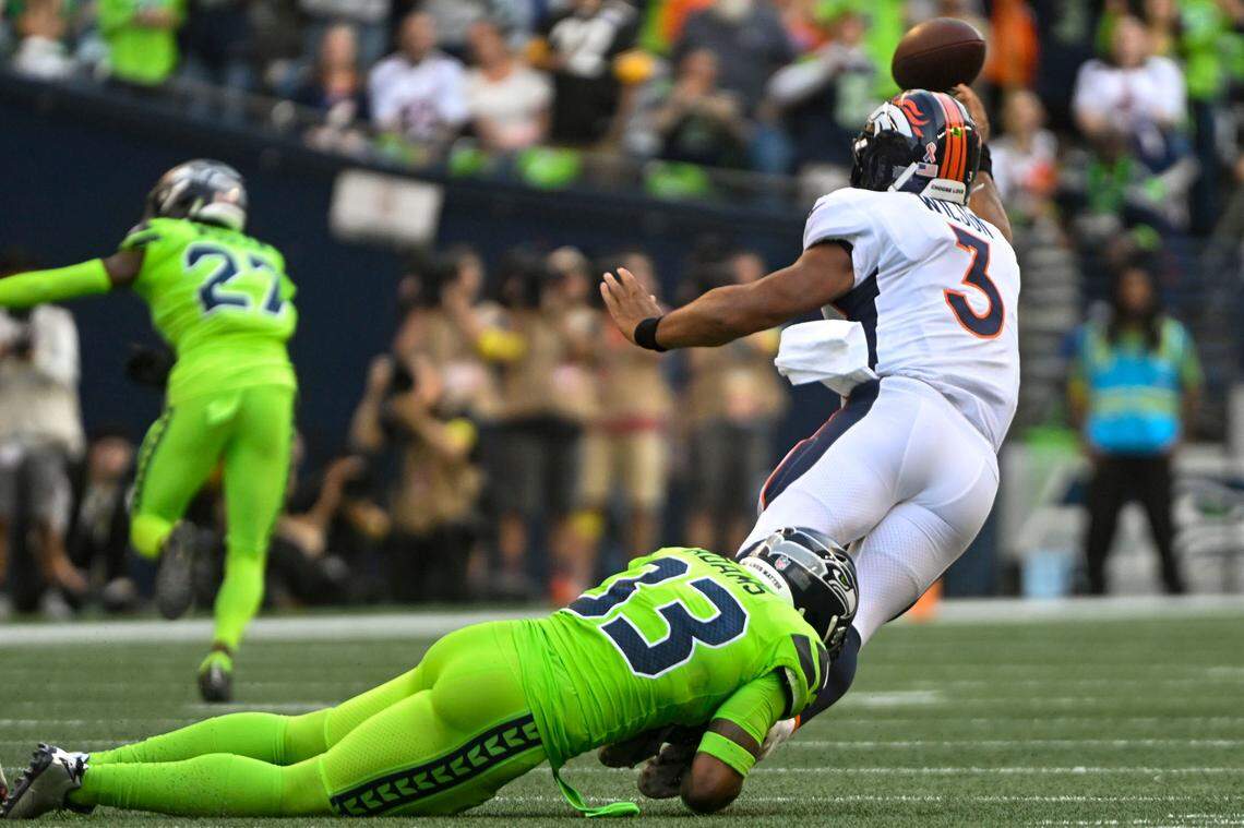 Denver Broncos quarterback Russell Wilson (3) gets a pass away before being tackled by Seattle Seahawks safety Jamal Adams (33) during the first quarter of an NFL game on Monday, Sept. 12, 2022, at Lumen Field in Seattle.