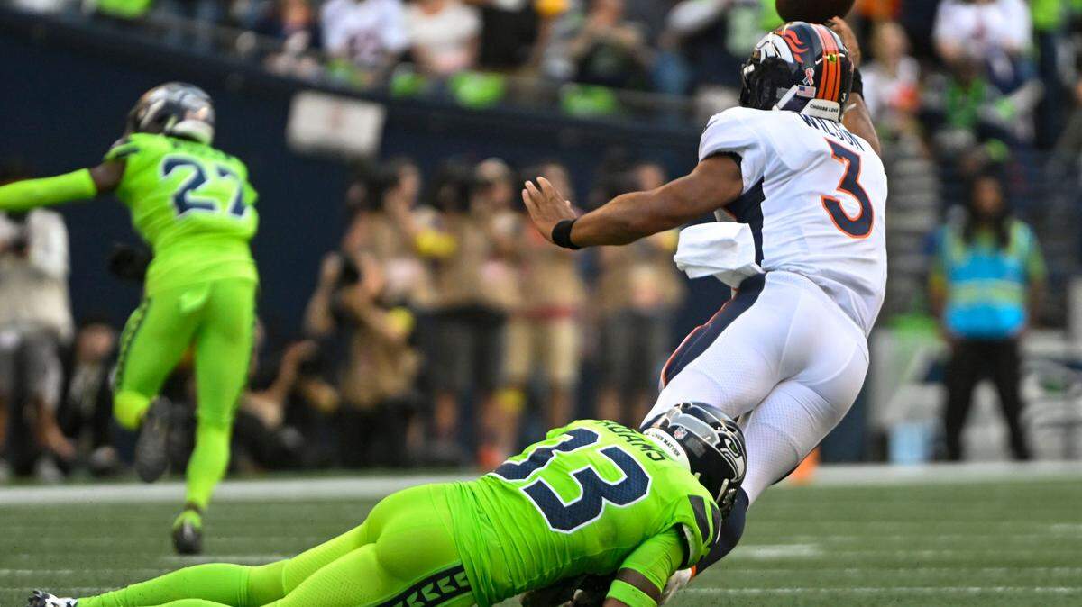 Denver Broncos quarterback Russell Wilson (3) gets a pass away before being tackled by Seattle Seahawks safety Jamal Adams (33) during the first quarter of an NFL game on Monday, Sept. 12, 2022, at Lumen Field in Seattle.