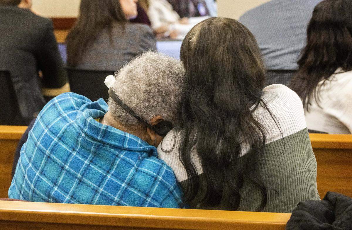 Two women embrace when a video is shown during the trial for the murder of Manny Ellis in Pierce County Superior Court in Tacoma Wednesday, October 4, 2023. On the video, someone yelled out, “Just arrest him.” Ellis was killed during the arrest and the three Tacoma police officers who arrested him are on trial for his death. (Ellen Banner / Pool Photo - The Seattle Times)