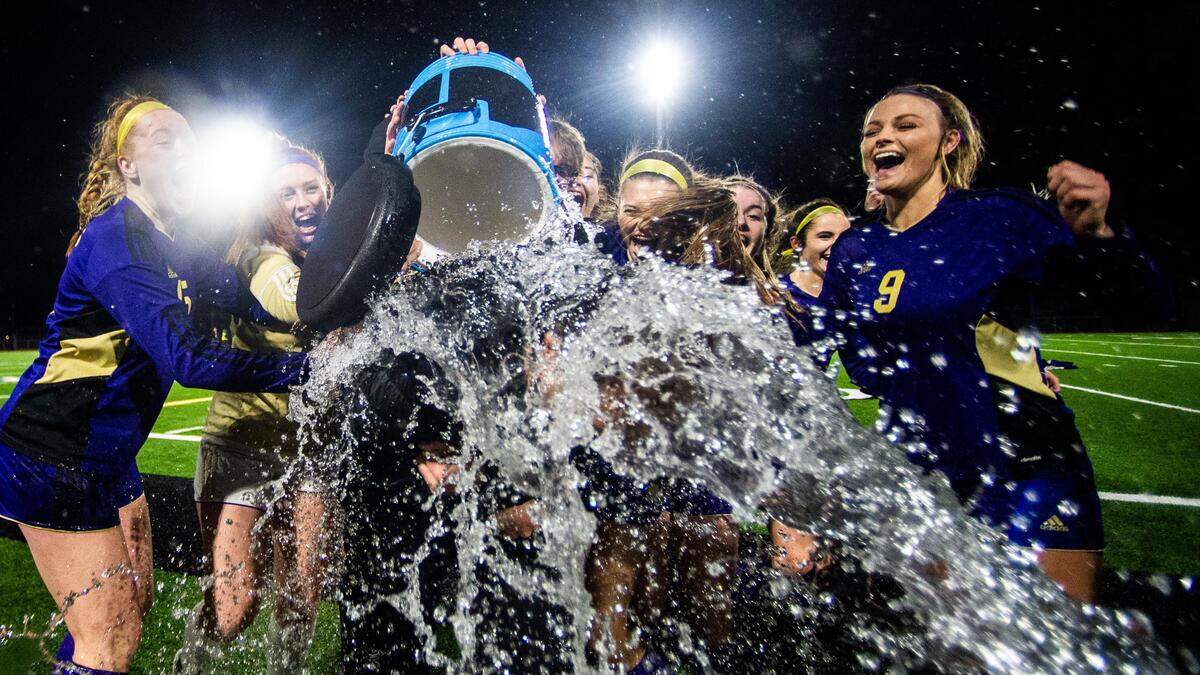 Puyallup players dump water onto their coach in celebration after winning the State Championship. Puyallup played Auburn Riverside in the WIAA 4A Girls Soccer State Championship game at Sparks Stadium in Puyallup, Wash., on Saturday, Nov. 23, 2019.