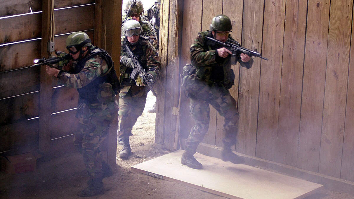 After breaching the door, Special Forces intructors enter a building, Dec. 21, 2000, during a mock take-over during close-quarters training for Special Forces at Fort Bragg N.C. Special operations troops at Joint Base Lewis-McChord will be conducting similar exercises this weekend.