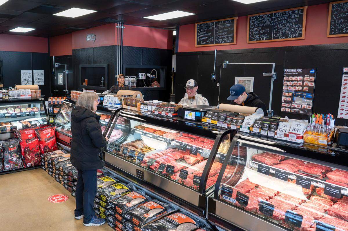 Joseph Boyle, center right, helps a customer with selecting steaks at Blue Max Meats in Puyallup on May 21. The Summit shop offers more than 2,000 items, including spices, sauces and other grilling essentials.