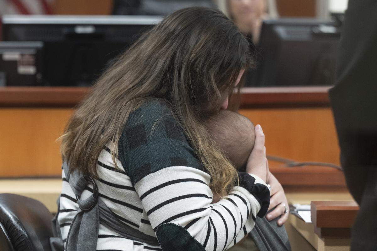 Victim Amber Arciniega kisses the top of her baby’s head as she speaks at the sentencing of former Pierce County Sheriff’s Office Maj. Chadwick Dickerson on Tuesday, April 14, 2026, at Pierce County Superior Court in Tacoma. Arciniega was pregnant with her child at the time of the accident.