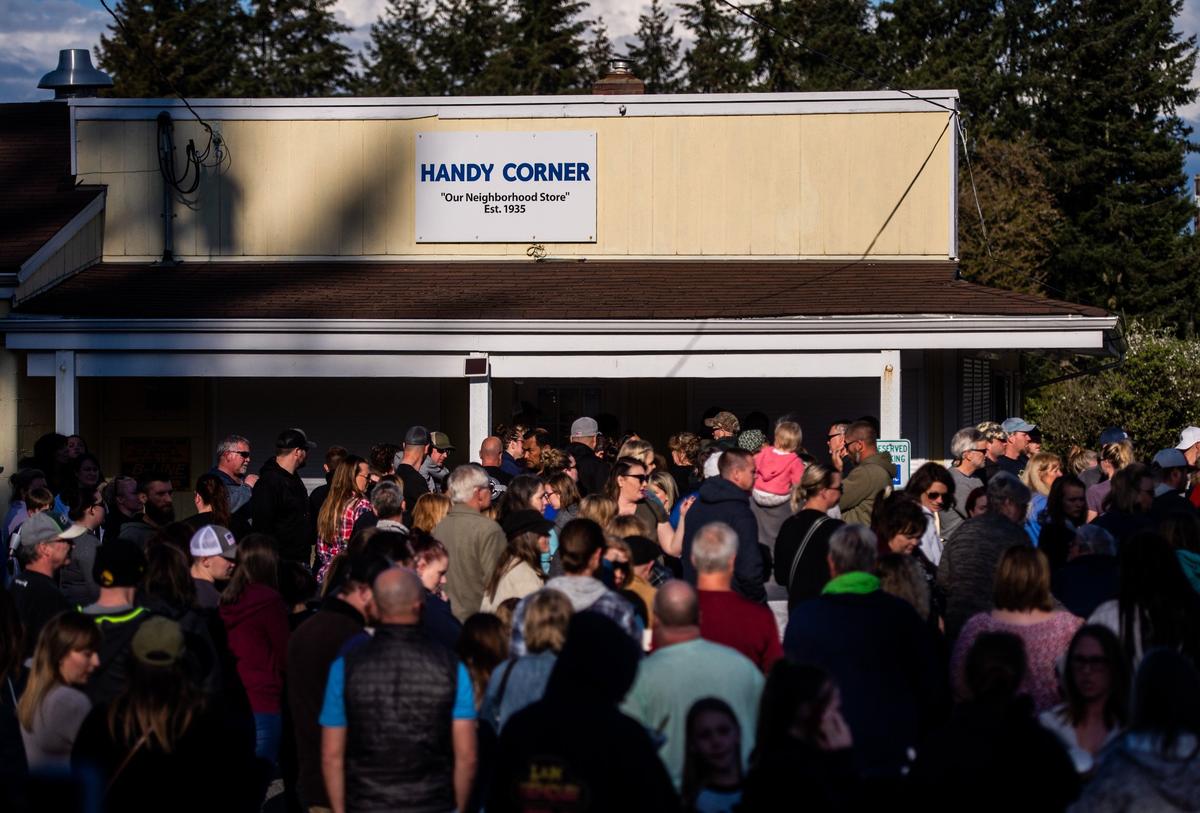 People gather for a candlelight vigil for Soon Ja Nam, 79, who owned the Handy Corner Store in Puyallup, Wash., on Sunday, April 28, 2019. Nam was shot and killed during a robbery Saturday night.
