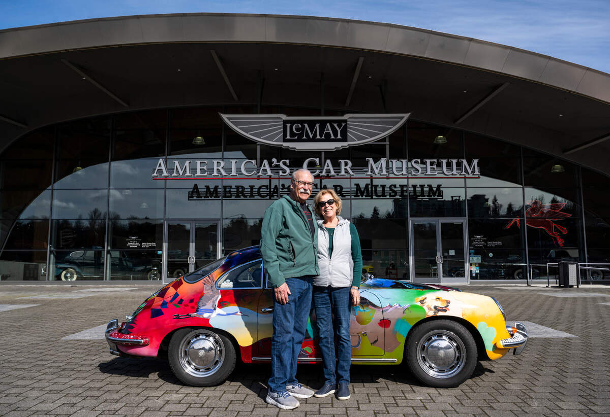 Rick and Sally Danielson of Graham pose for a portrait with their 1965 Porsche 356 that was custom painted by artist, Zak Barnes, from Kansas in front of the Lemay — America’s Car Museum in Tacoma on March 14, 2023. The Danielson’s loaned a 1956 Porsche 356 A Rally to the museum for its new exhibition, “Porsche at 75.”