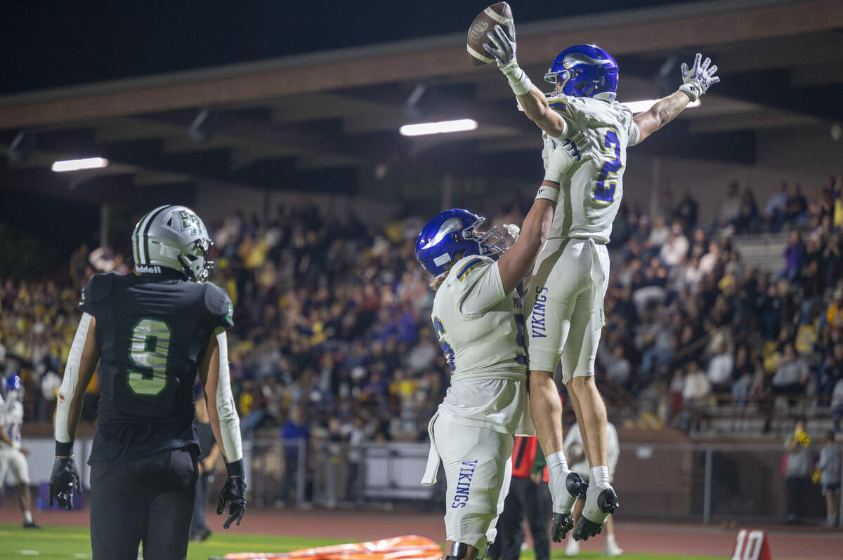 Puyallup’s Cova Doyal (56), left, lifts Puyallup’s Jayden Woodland (2) in celebration of Woodland’s touchdown against Emerald Ridge on Friday, Sept. 26, 2025, in Puyallup.