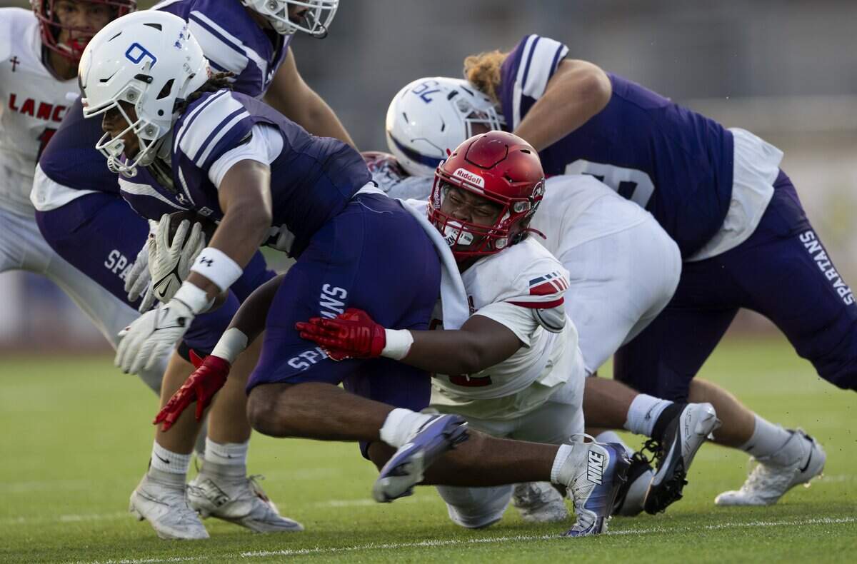 Sumner running back Lance McGee (9) is wrapped up by Kennedy Catholic inside linebacker Alexander Prince (52) during the first half of the game at Sunset Chev Stadium on Friday, Sept. 12, 2025, in Sumner, Wash.