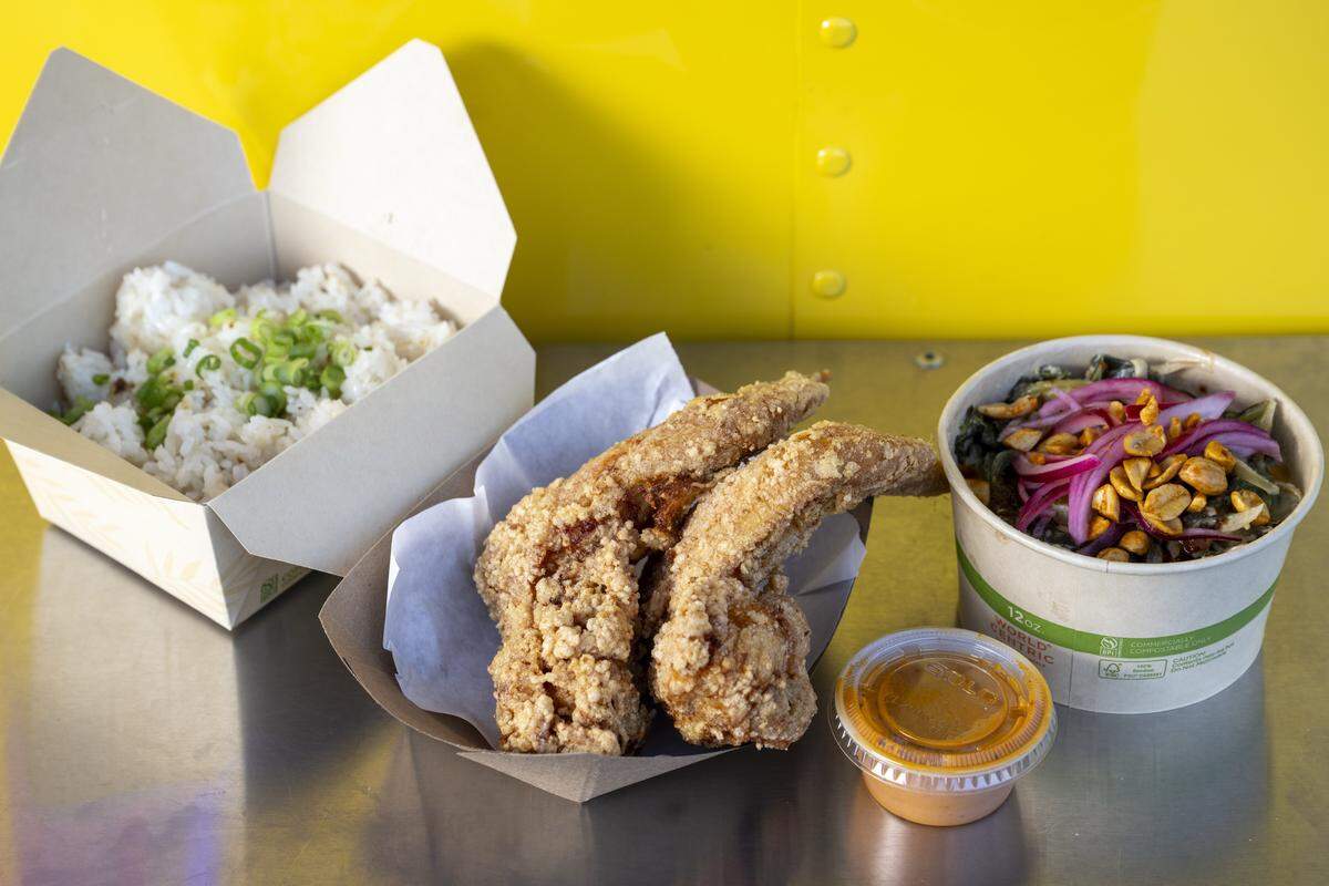An order of garlic rice, chicken wings and coconut collard greens are pictured at The Chicken Supply on Wednesday, Oct. 29, 2025, in Tacoma, Wash.