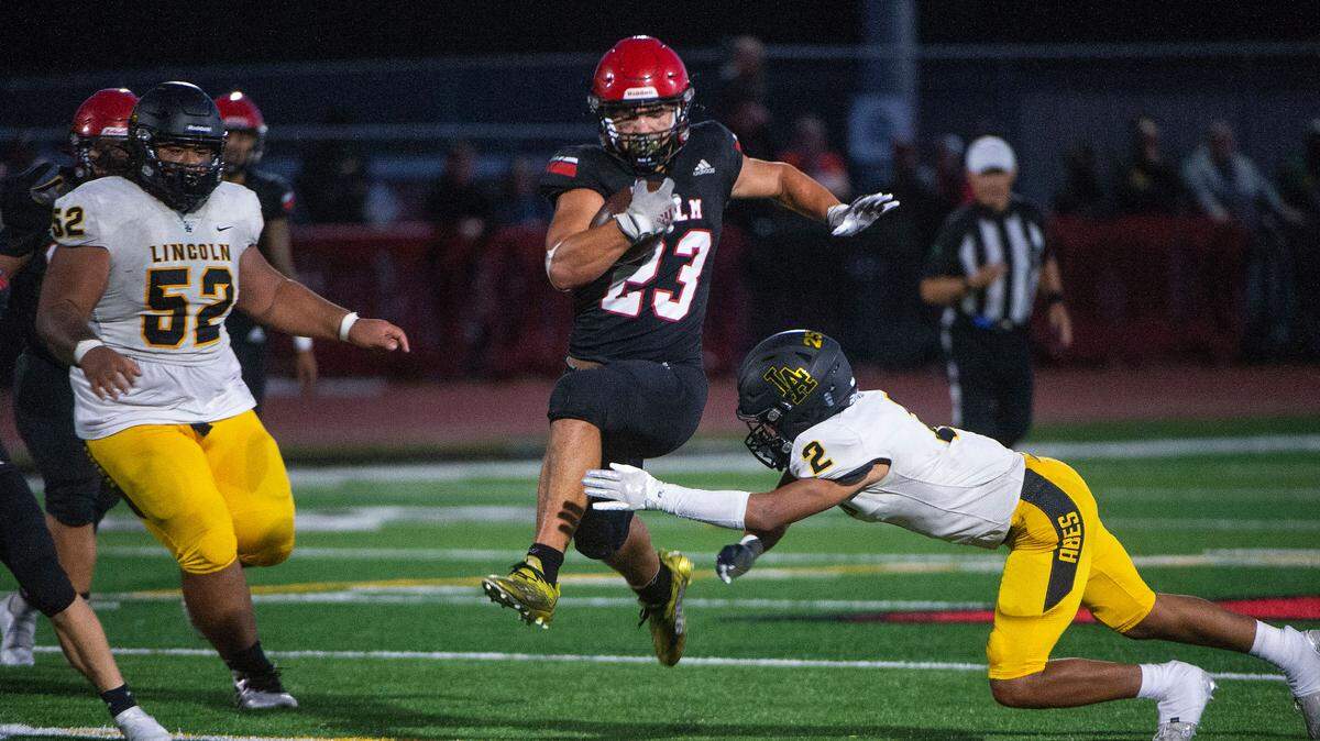 Yelm running back Brayden Platt, who rushed for 107 yards and 3 TDs, gallops past Lincoln defender Khaleel Robinson for a big gain in the Tornados’ 34-18 win over the Abes Friday, Sept. 3, 2021.