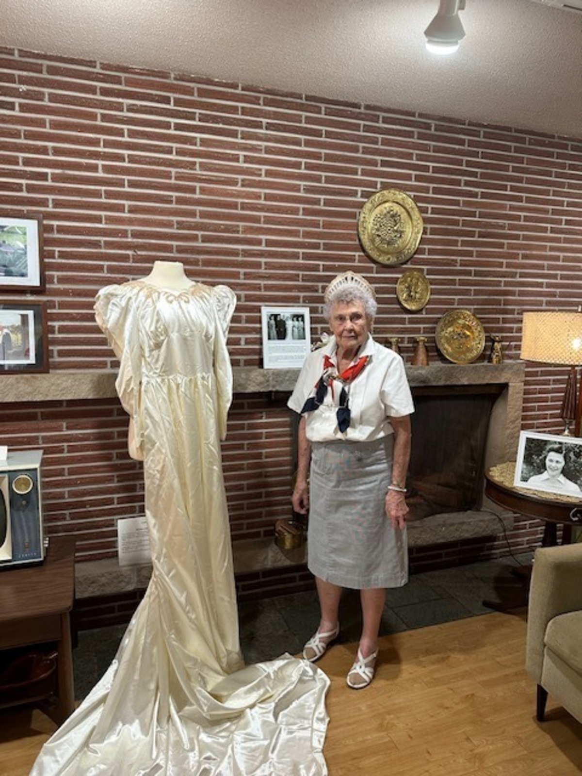 Betty Pasinetti poses with her wedding dress on display Aug. 12 at the Fife History Museum.
