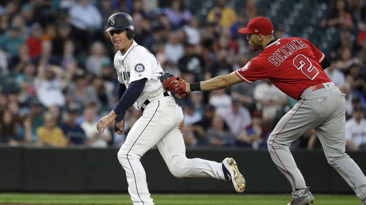 Los Angeles Angels shortstop Andrelton Simmons (2) tags out Seattle Mariners pinch runner Dylan Moore on a run-down in the seventh inning of a baseball game Saturday, July 20, 2019, in Seattle. (AP Photo/Elaine Thompson)