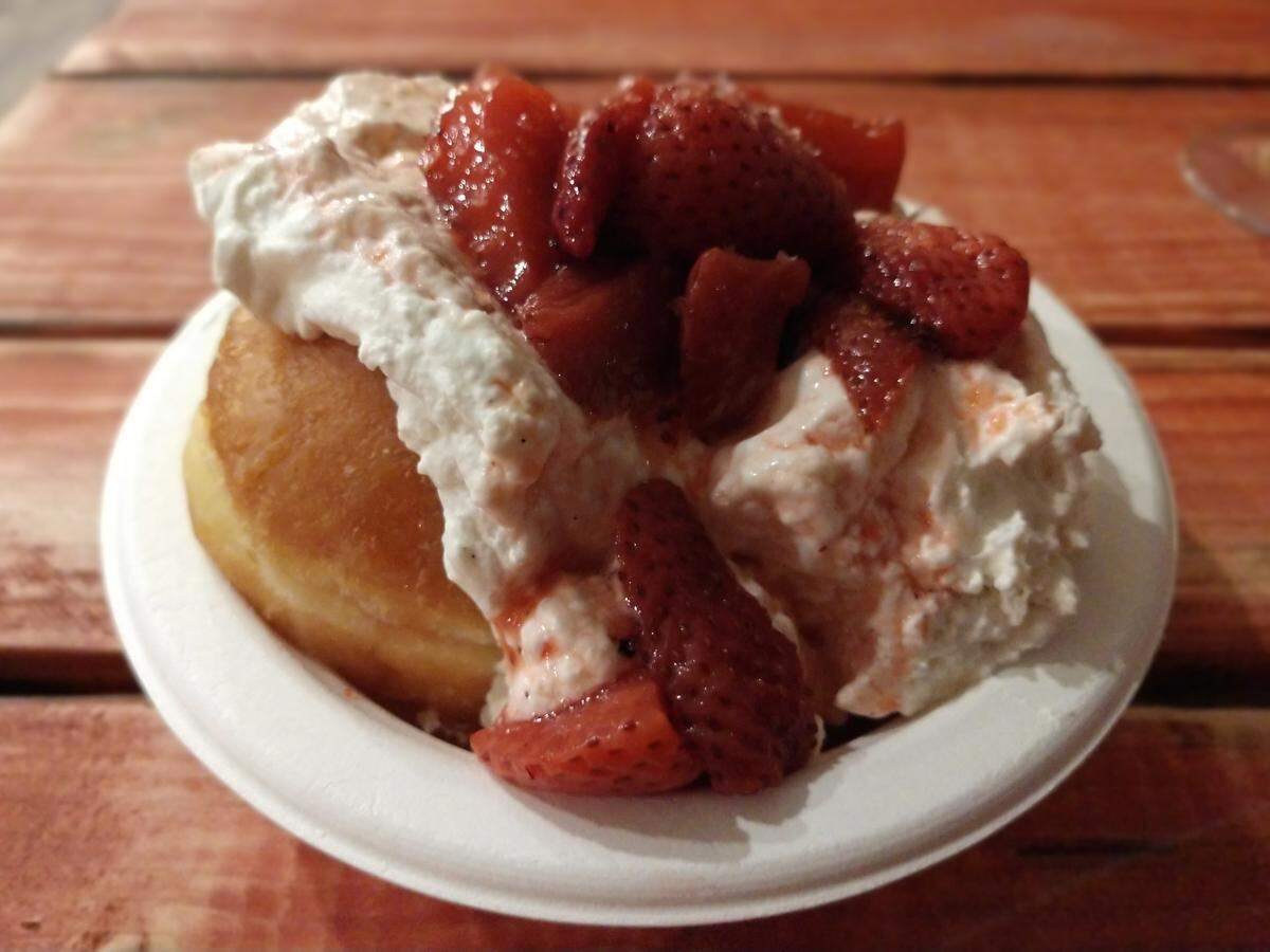 A big, fluffy doughnut with vanilla chantilly and strawberry sauce from Brimstone PNW.